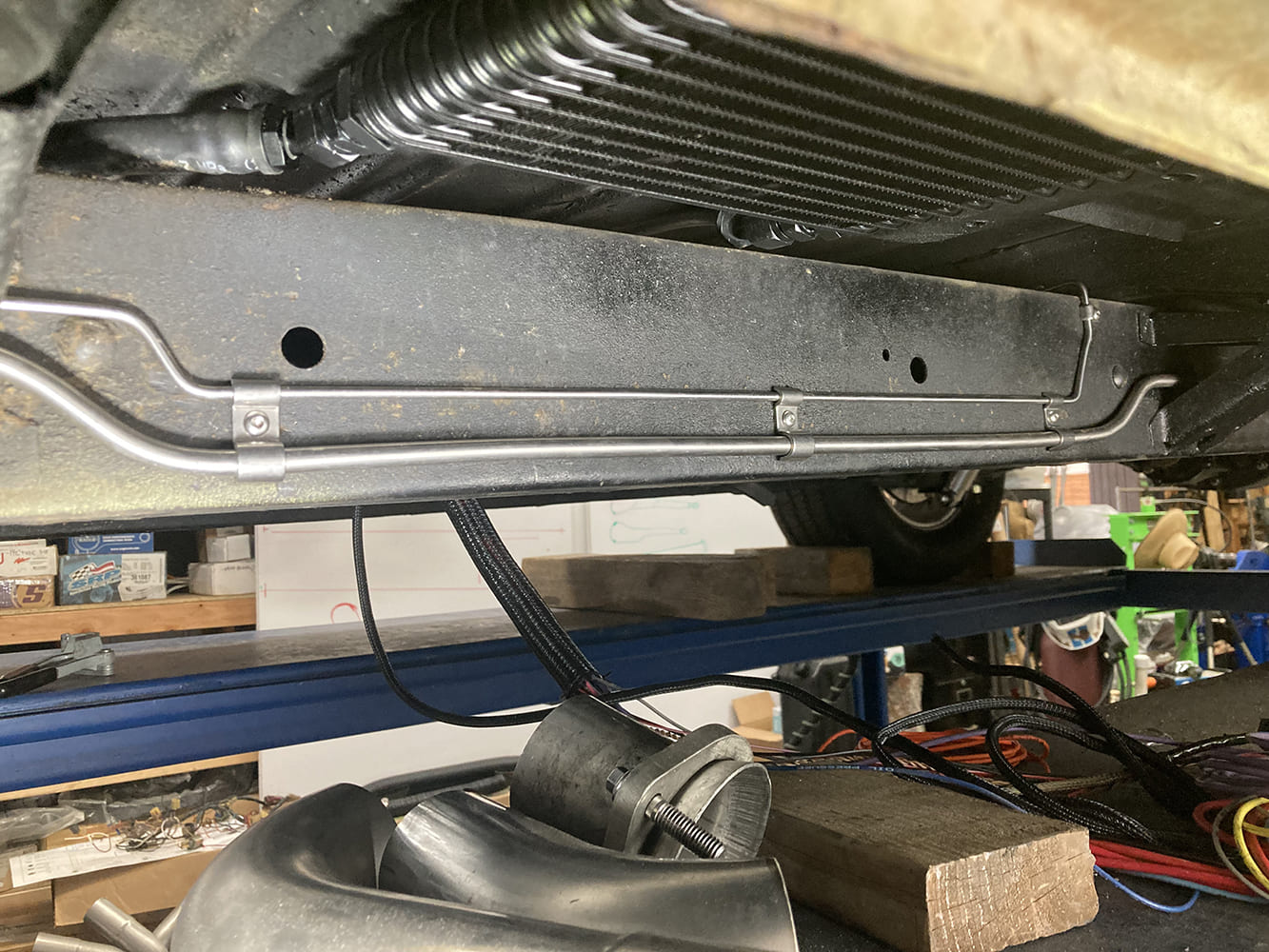 021 Dual stainless lines run parallel under driver frame rail near transmission cooler