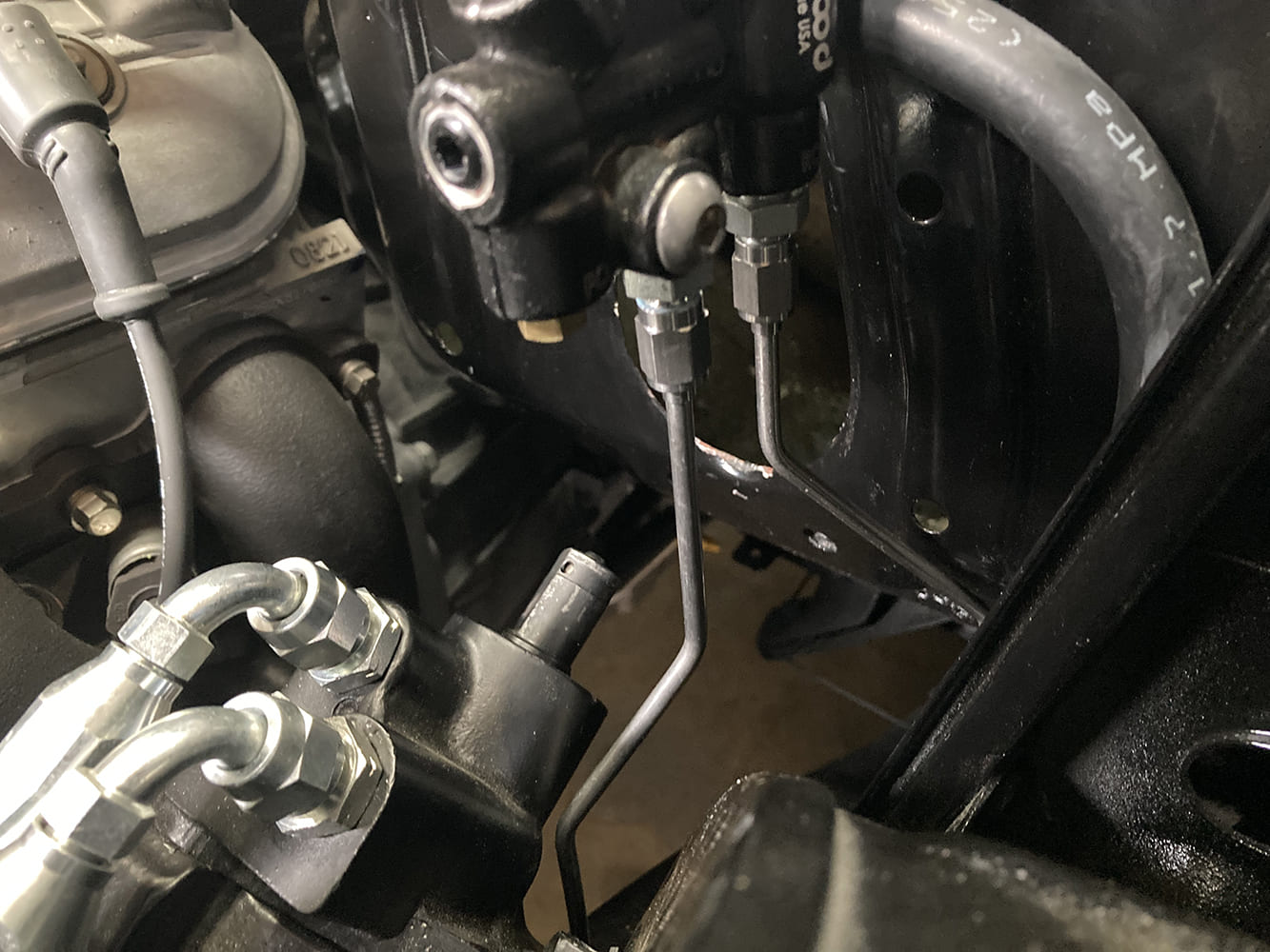 023 Wilwood master cylinder connected to bulkhead brake fittings on engine bay wall