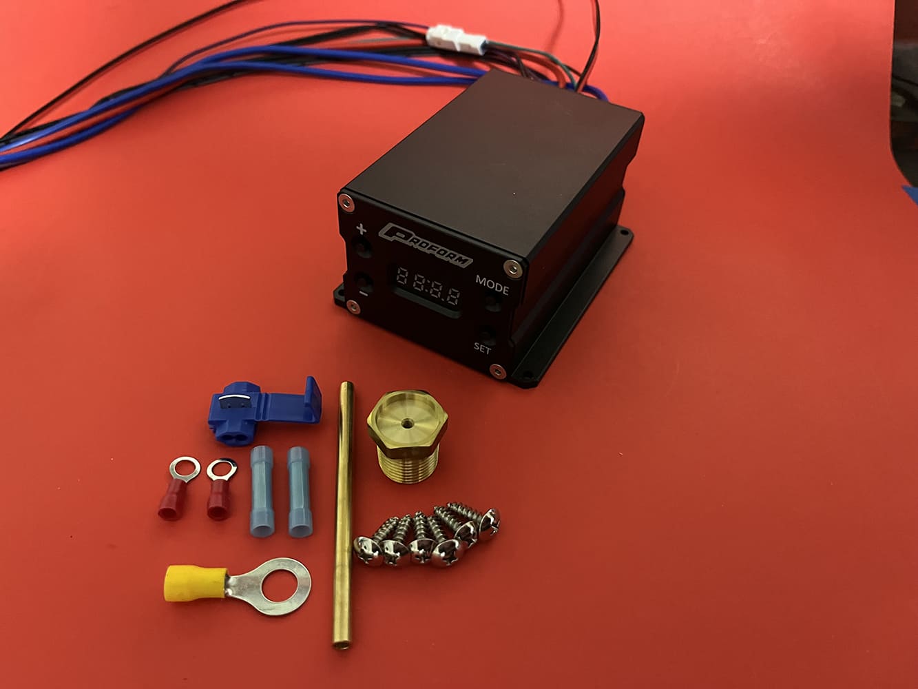03 Complete Proform fan controller kit including terminals sensor fitting and mounting hardware on red backdrop