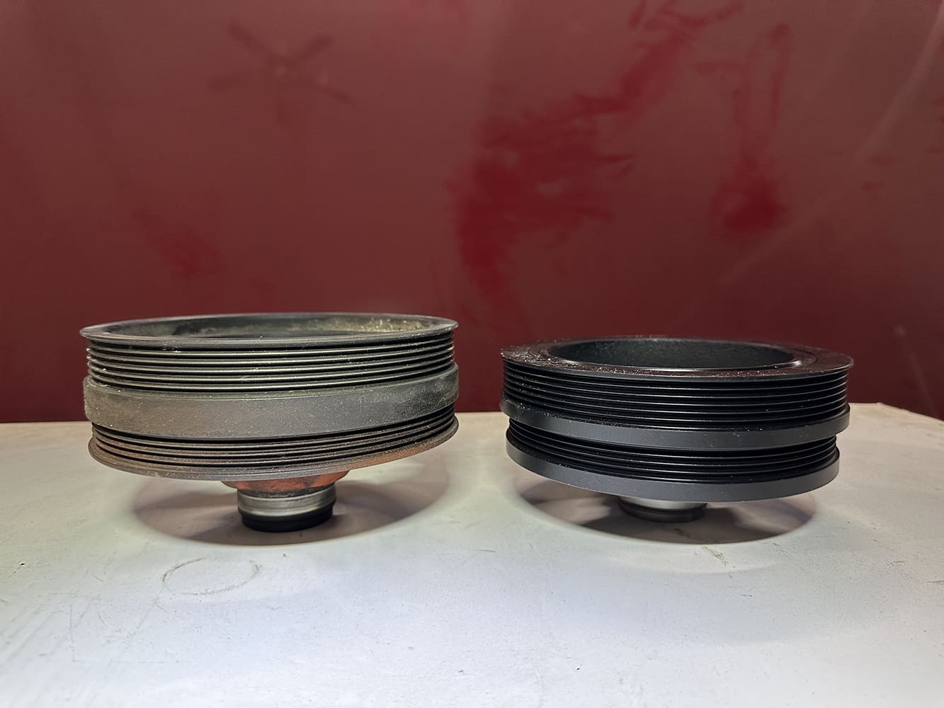 07 Side by side of original cast crank pulley and new black anodized billet pulley