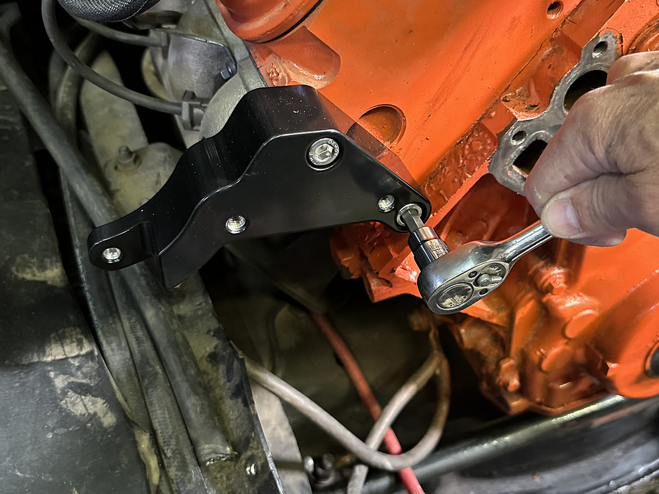 10 Passenger side Billet Specialties LS Sport Trac bracket being installed to cylinder head