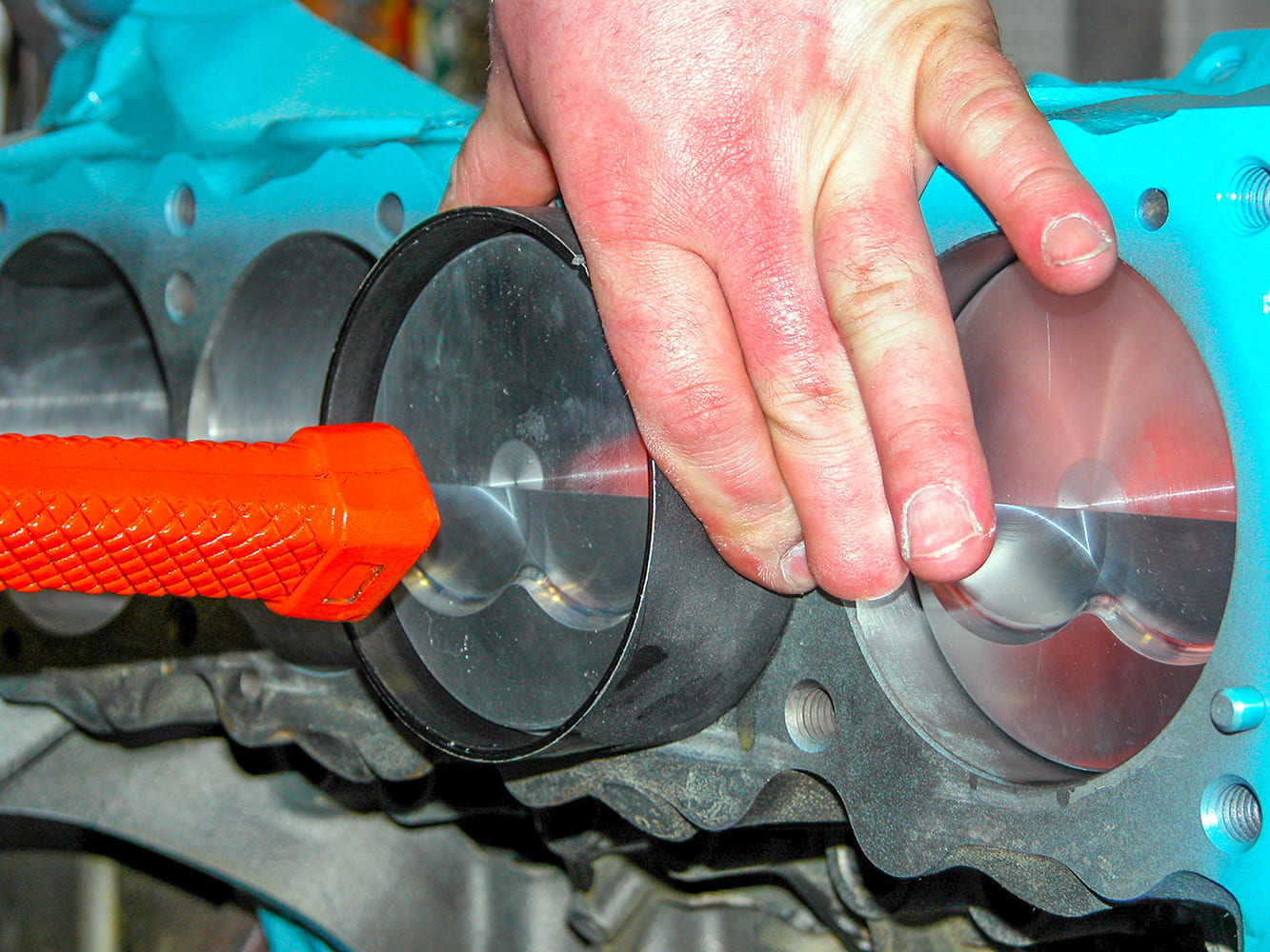 11 Forged piston with valve reliefs installed into Pontiac 428 block using ring compressor