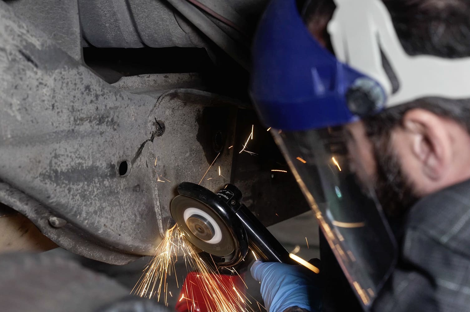 12 Technician uses angle grinder to trim inner fender structure for suspension fitment