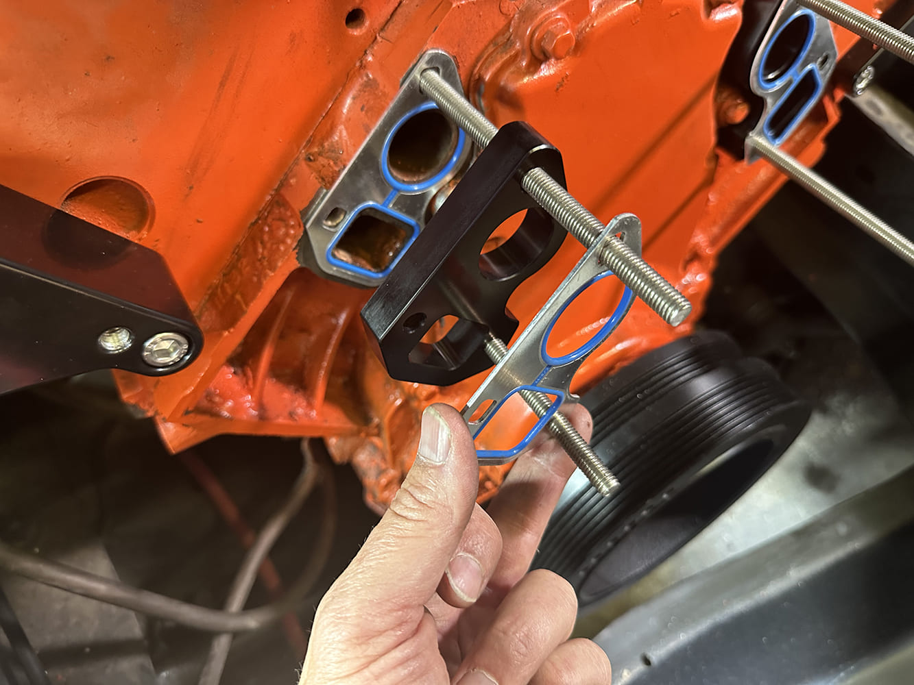14 Coolant crossover and gaskets installed with water pump studs on LS engine block