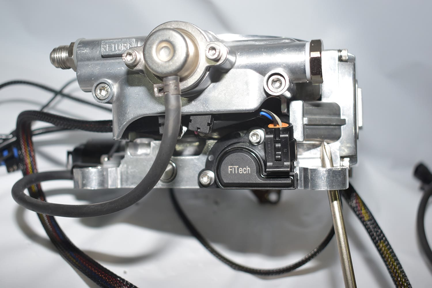 14 FiTech throttle body side showing TPS sensor and labeled return fuel port