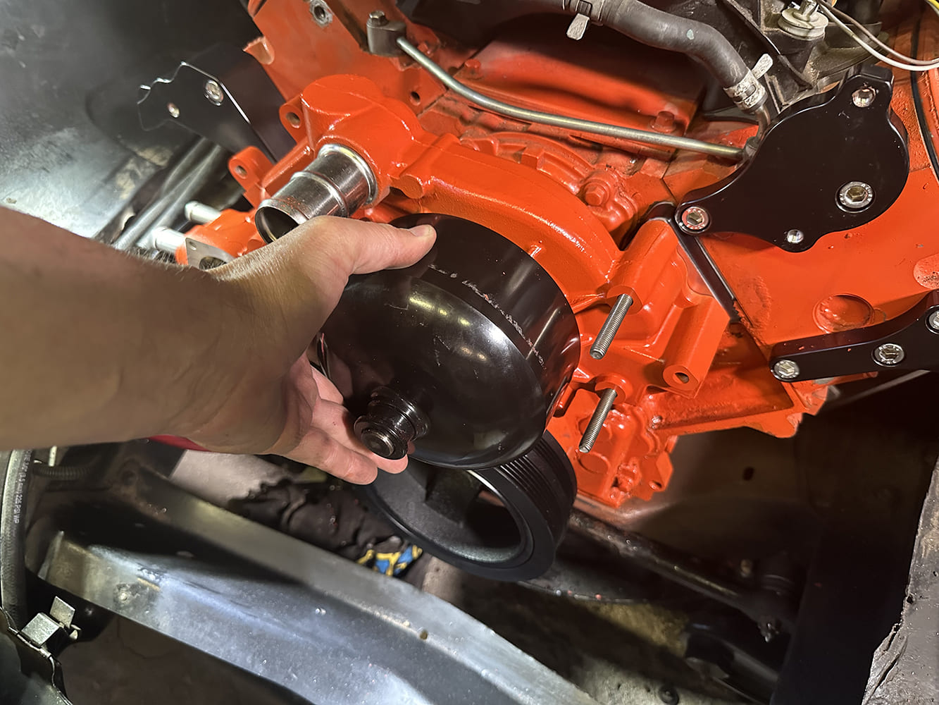 15 ACDelco water pump being test fitted between billet brackets for final alignment