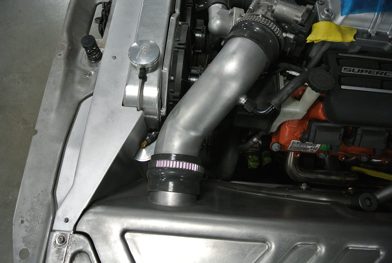 19 Cold air intake tube mocked into bead rolled inner fender with precision grommet pass through