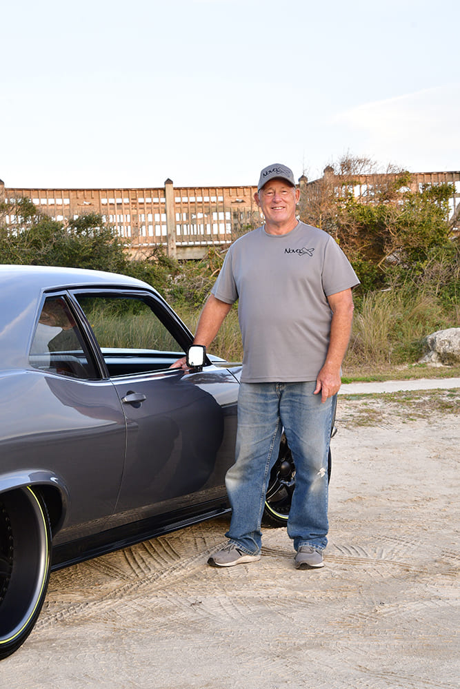 019 1968 Chevy Nova owner proudly poses beside the fully restored and modified Nova X