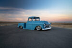 02 1957 Chevy truck turquoise stepside pickup with smoothed body lines and chrome grille at sunset