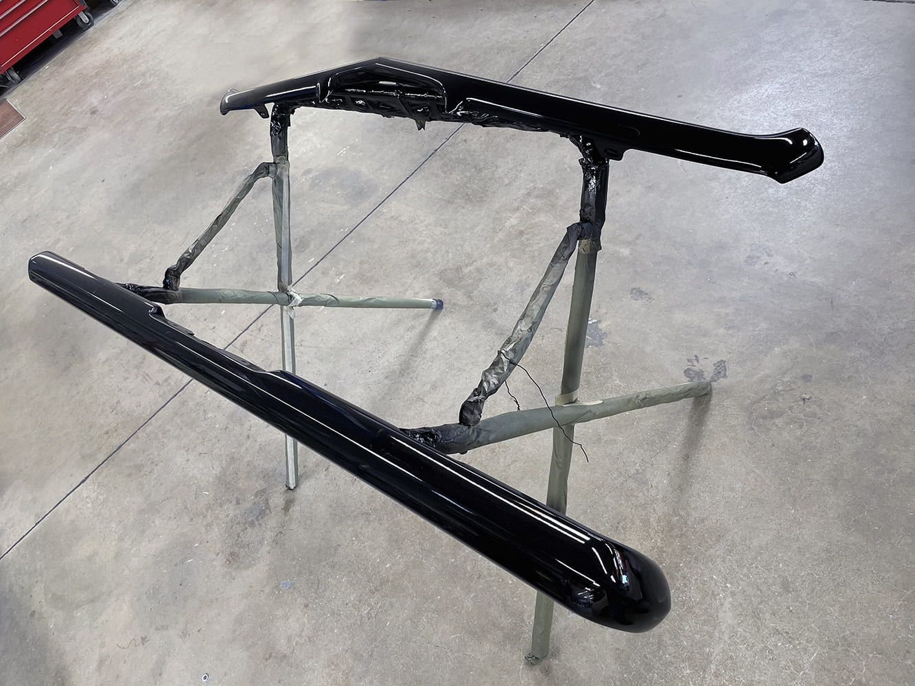 020 1969 Camaro bumpers fully painted gloss black and staged for final installation