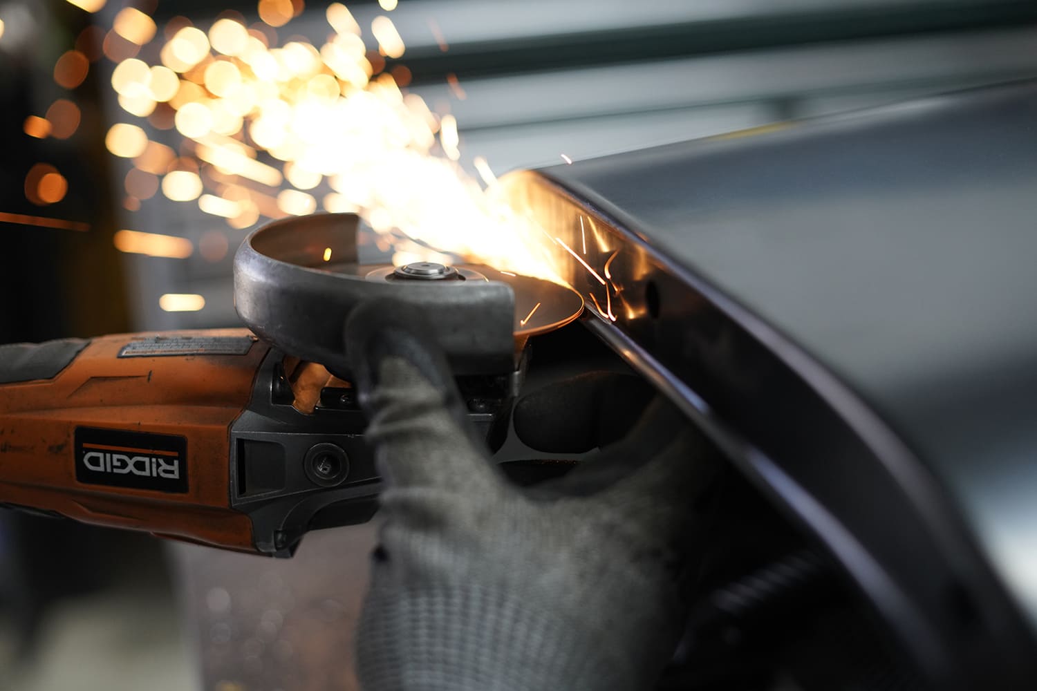 19 Sparks fly from a Ridgid angle grinder trimming the edge of a new steel wheel tub