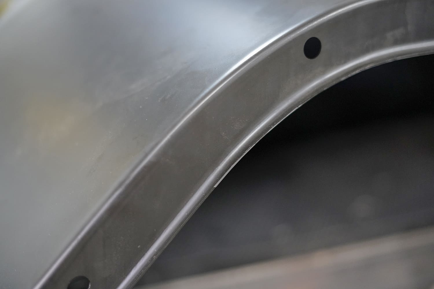20 Close up of a formed wheel tub arch shows precision stamping and pre drilled mounting holes for final installation