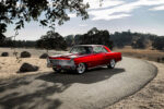 001 1966 Chevy Nova in candy red with Billet Specialties wheels and lowered stance on a mountain road