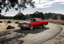 001 1966 Chevy Nova in candy red with Billet Specialties wheels and lowered stance on a mountain road
