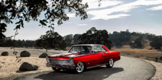 001 1966 Chevy Nova in candy red with Billet Specialties wheels and lowered stance on a mountain road