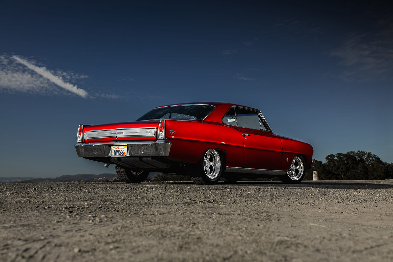 006 1966 Chevy Nova street machine from rear angle tucking chrome wheels under lowered suspension