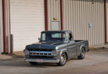 01 1957 Ford F 100 custom build in slate gray with chrome trim parked at industrial building
