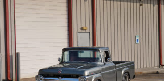 01 1957 Ford F 100 custom build in slate gray with chrome trim parked at industrial building