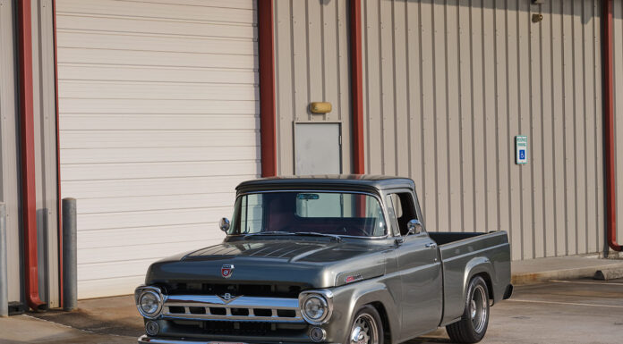 01 1957 Ford F 100 custom build in slate gray with chrome trim parked at industrial building