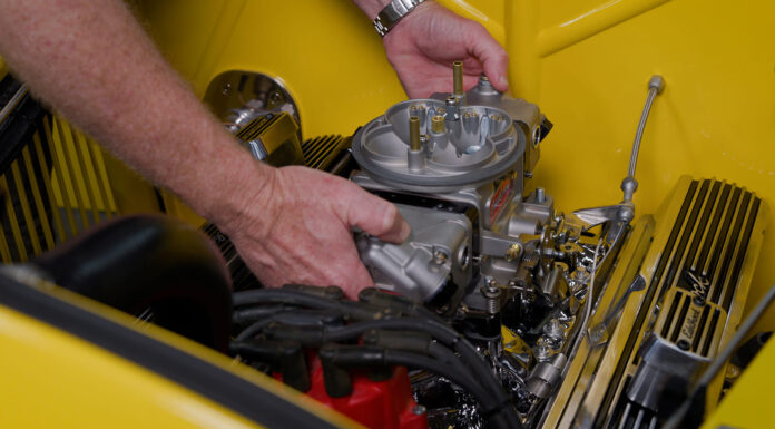 All About the Edelbrock VRS-4150 Four Barrel Carb 01 Edelbrock VRS 4150 carburetor being installed on a classic V8 with finned valve covers