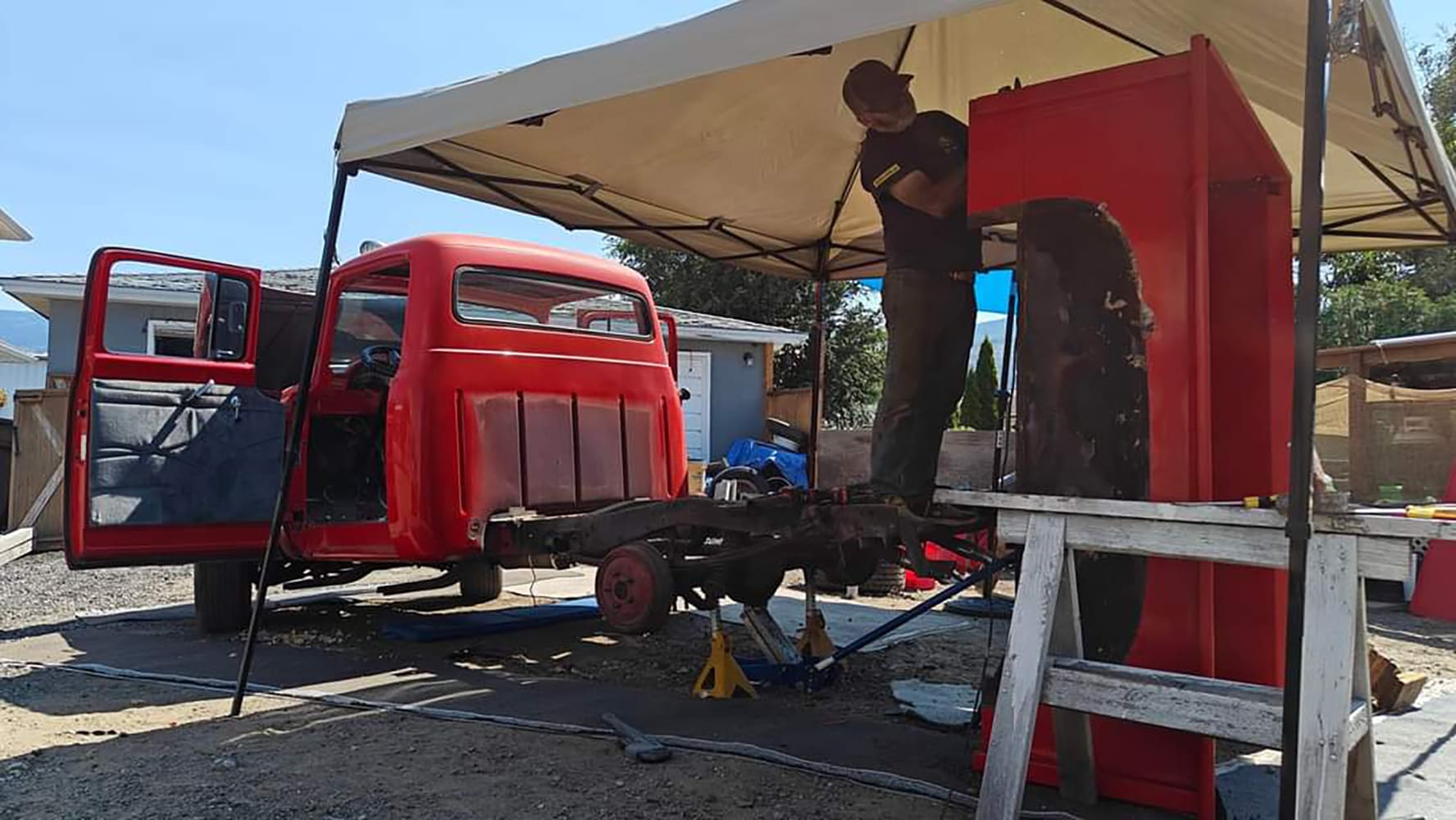 02 1956 Ford F 100 technician cutting cab lower rear section using angle grinder