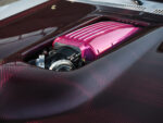 020 1969 Chevy Nova hood cutout reveals pink powder coated intake atop 632 big block