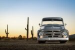 03 1956 Ford F 100 front profile with custom grille and sunset desert backdrop