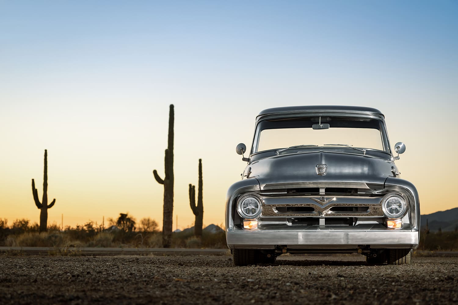 03 1956 Ford F 100 front profile with custom grille and sunset desert backdrop