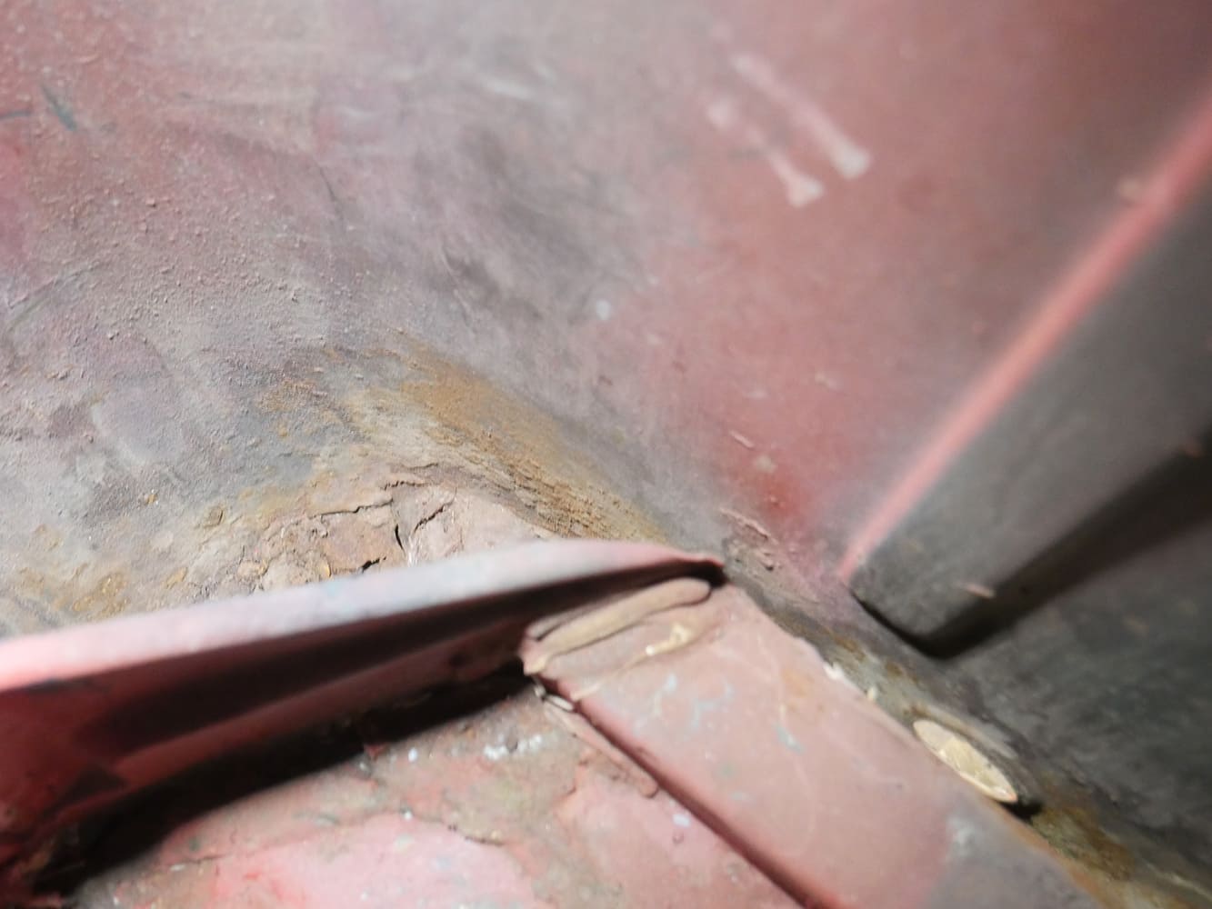 05 1956 Ford F 100 lower door jamb shows filler over rusted metal near floor pan