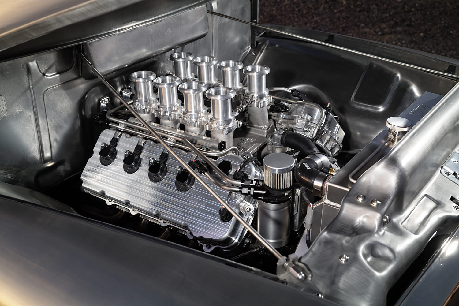 07 1956 Ford F 100 engine bay featuring billet intake stacks and custom coil covers
