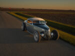 08 1936 Ford highboy parked at country crossroads with golden interior reflecting in windshield