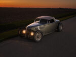 10 1936 Ford highboy at night with headlights lit clean body lines and chopped cloth top