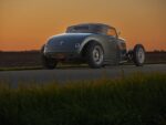 11 1936 Ford highboy rear quarter view with tucked tail lights smooth decklid and billet wheels at dusk