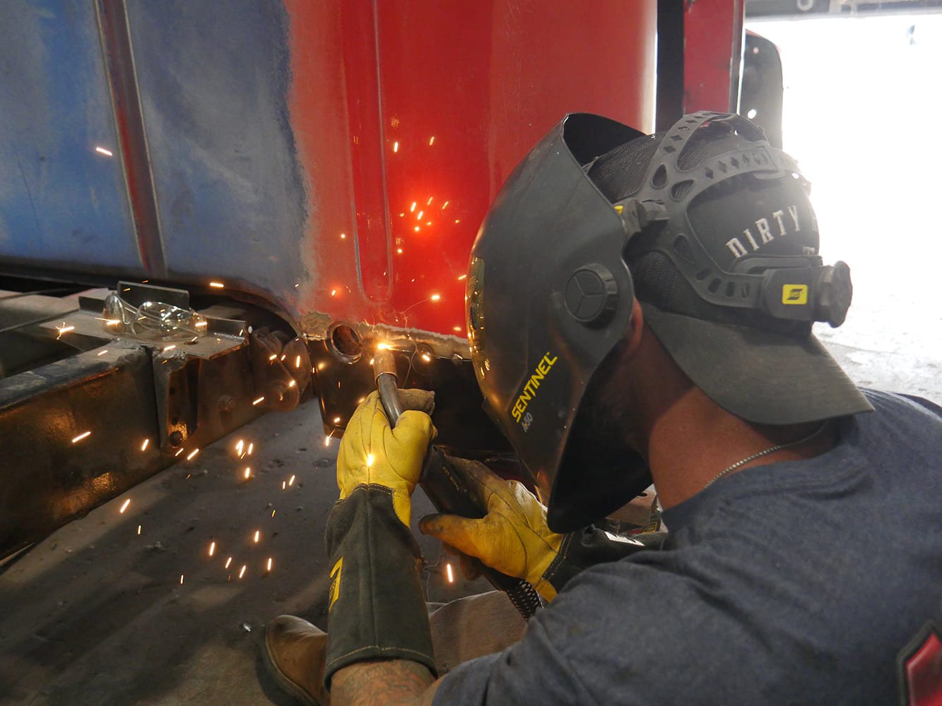 15 1956 Ford F 100 grinding patch panel welds smooth at cab lower rear corner