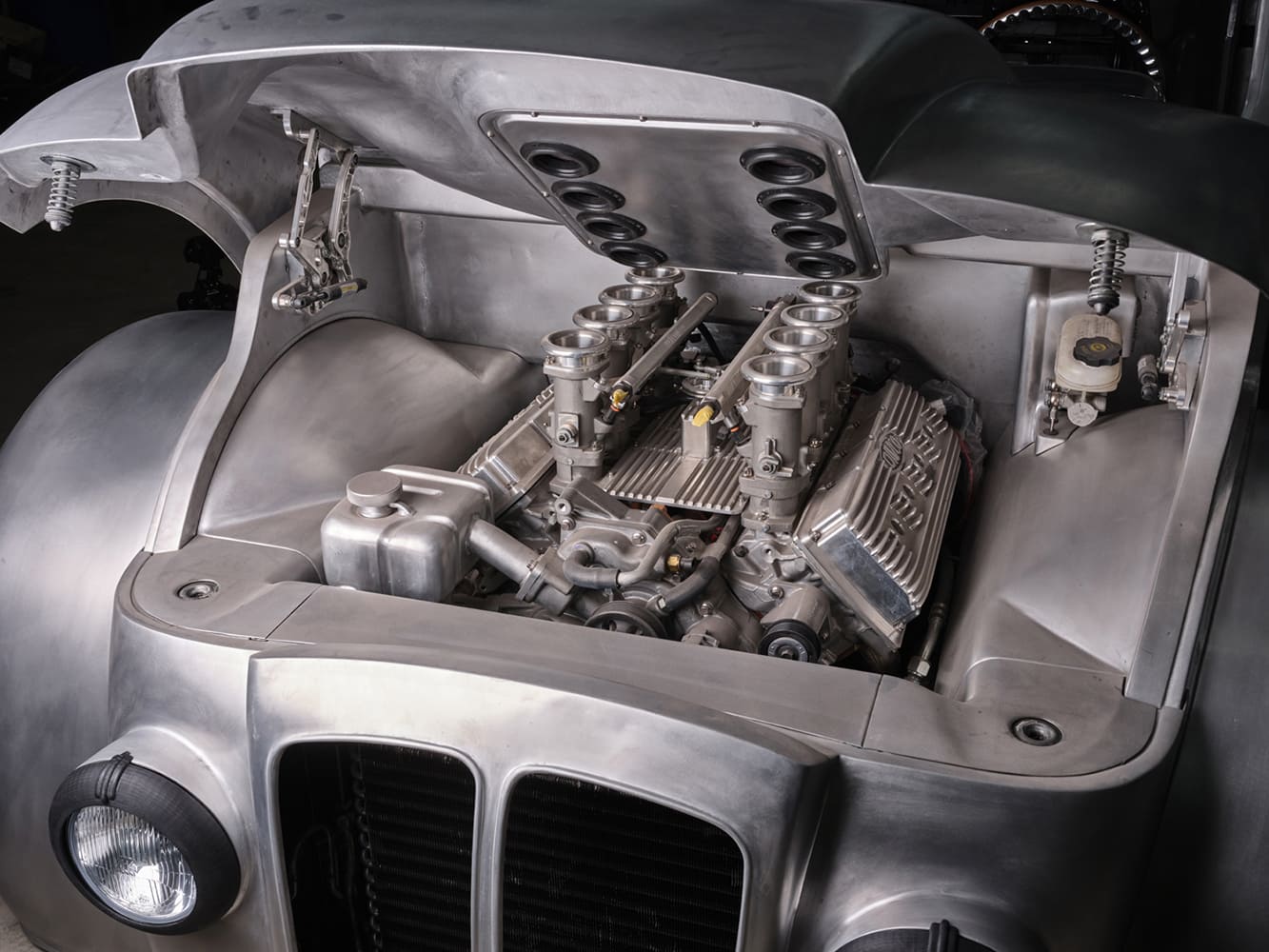 25 Divco hood raised revealing custom aluminum engine bay and velocity stack ITBs