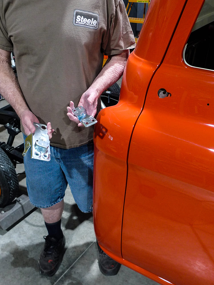 25 Steele Rubber installer holding door hinge brackets for Chevy truck door fitment