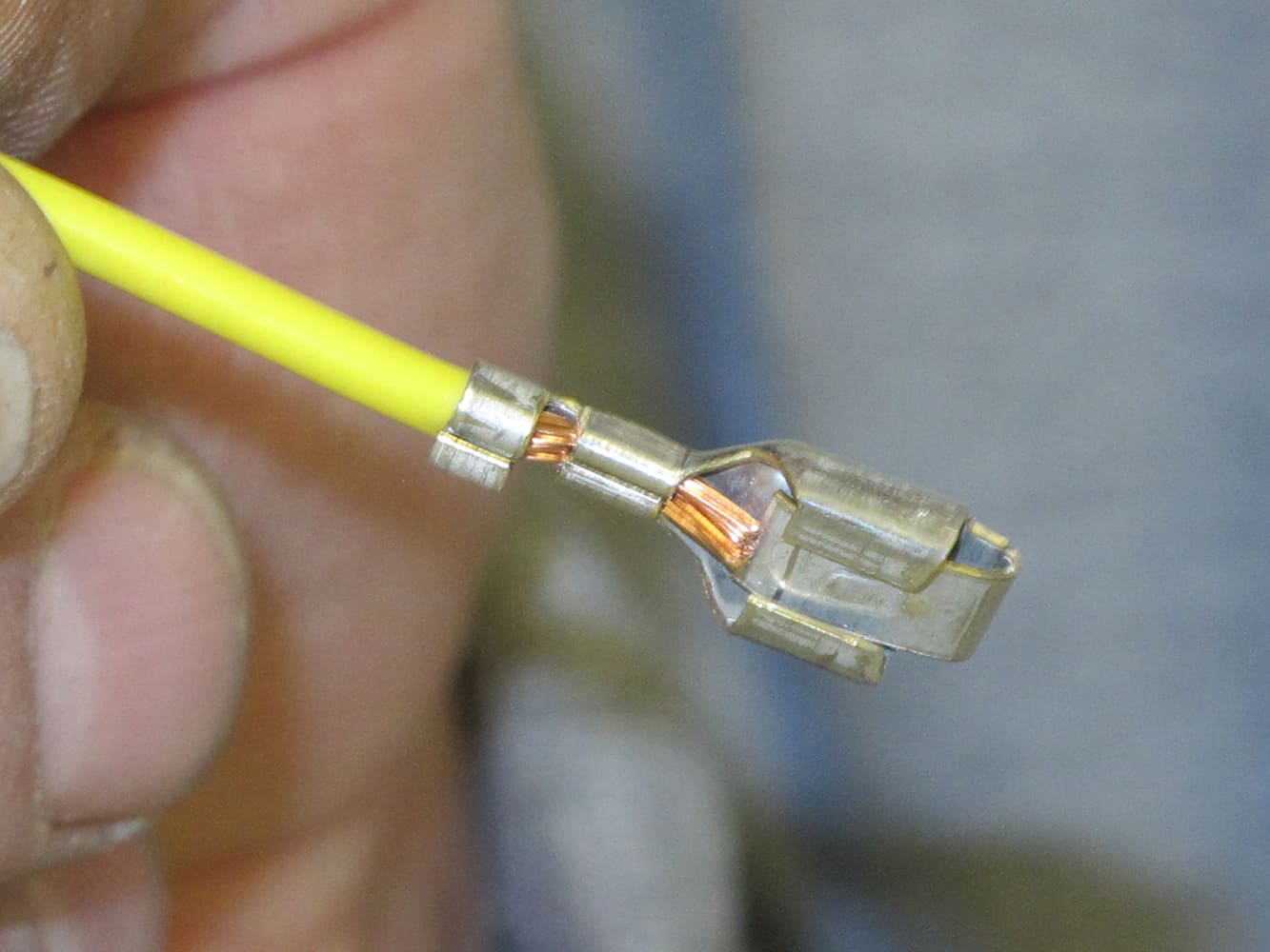 27 close up crimped terminal on yellow wire showing clean copper connection