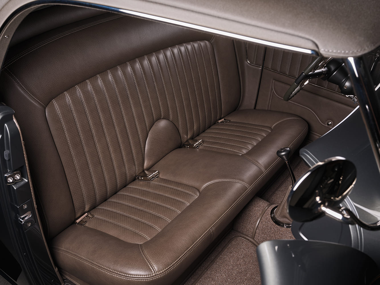 30 1936 Ford highboy brown leather bench seat with custom stitching seatbelts and shifter visible in cabin