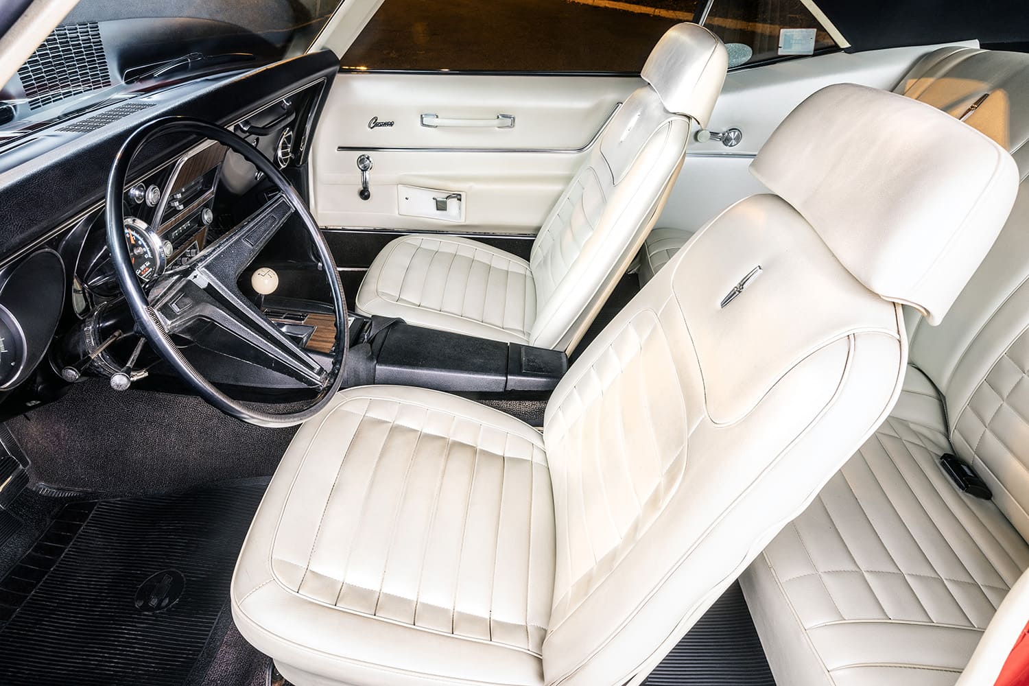 011 1968 Chevrolet Camaro interior with ivory bucket seats woodgrain console and black dash trim