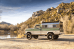 02 1969 Ford F 250 4x4 parked lakeside showcasing tall lift polished camper shell and rugged off road stance