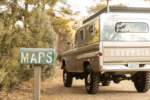 33 1959 Chevrolet Apache camper truck parked beside vintage MAPS sign in wooded backcountry area