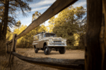 35 1959 Chevrolet Apache custom camper seen through rustic wooden fence on pine trail loop