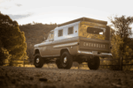39 1959 Chevrolet Apache camper truck rear profile in golden hour lighting with lifted stance and retro camper shell