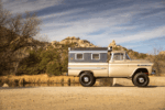 48 1959 Chevrolet Apache side profile showing lifted stance and riveted pop up camper in rocky landscape