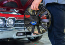 001 Proform 16 inch brushless electric fan hand held next to classic red 1969 Chevrolet