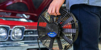 001 Proform 16 inch brushless electric fan hand held next to classic red 1969 Chevrolet