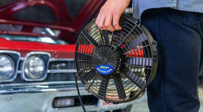 001 Proform 16 inch brushless electric fan hand held next to classic red 1969 Chevrolet