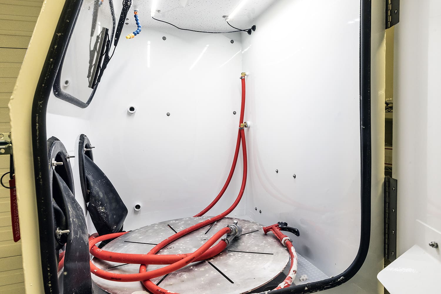 009 interior view of vapor honing cabinet with turntable and blast gun