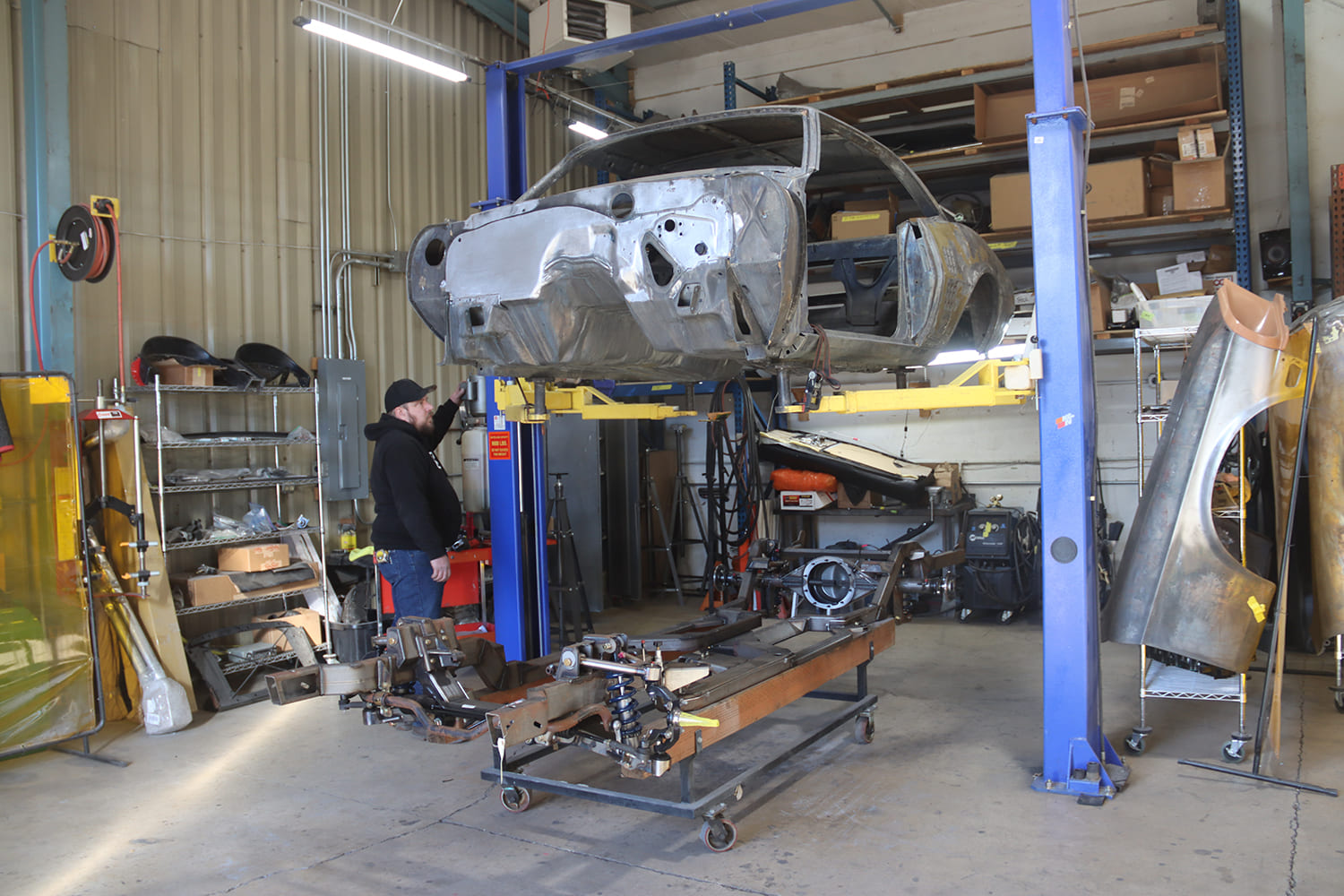 02 1967 Pontiac Firebird bare shell on lift above custom chassis jig during full frame off restoration