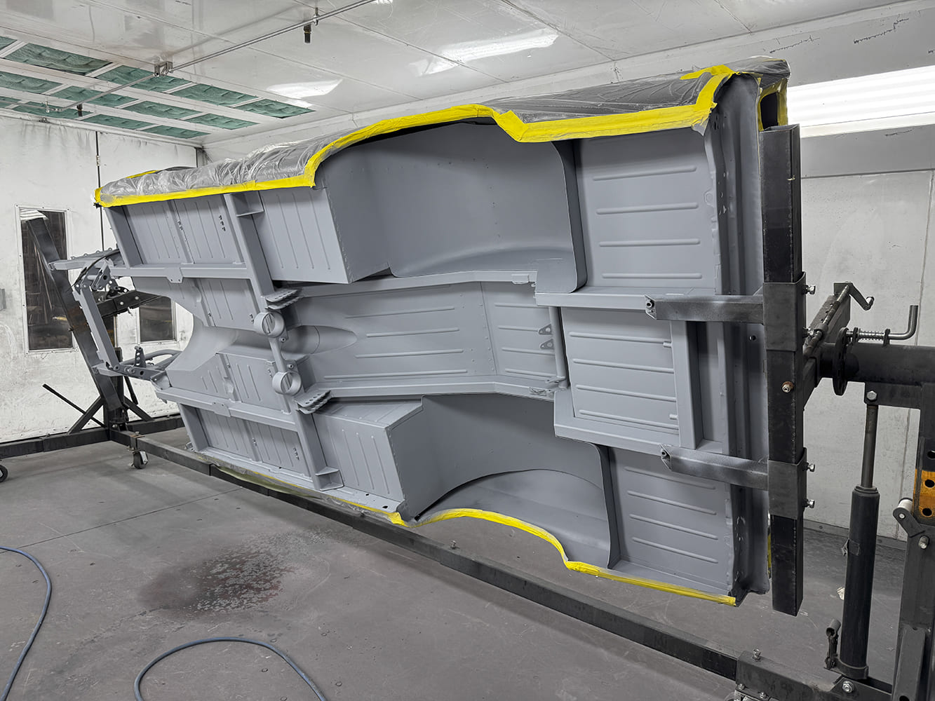 027 Undercarriage of 1963 Chevy Nova in gray primer rotisserie setup